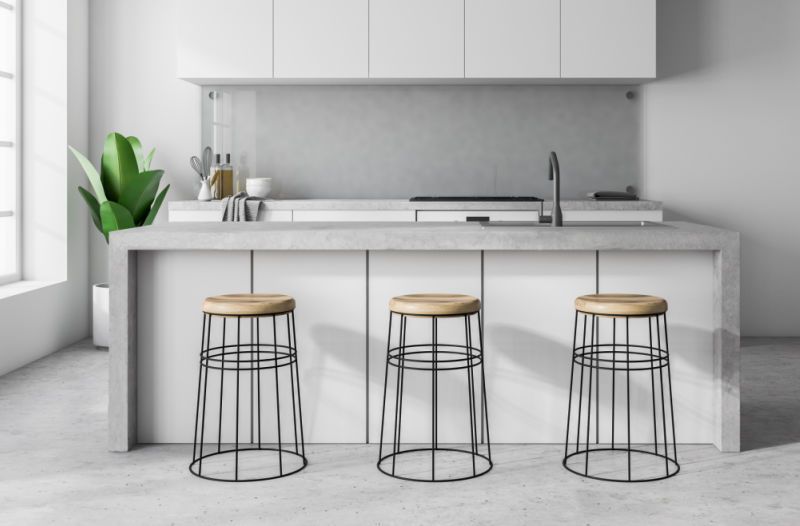 concrete countertops on a kitchen island in a minimalist white kitchen