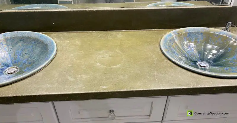 stains and etching on concrete bathroom countertop with blue sinks