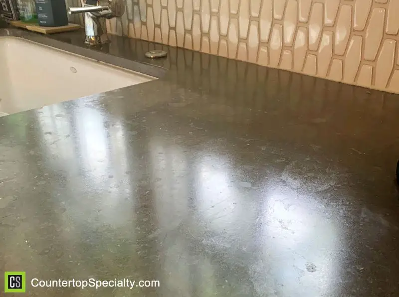 dull water stains from acid etching on black limestone kitchen countertops