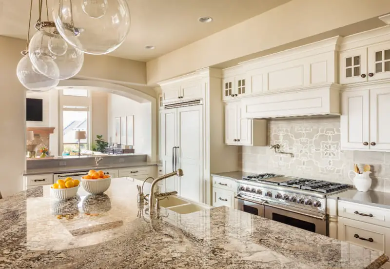 modern kitchen design with gray granite countertops on island and white cabinets