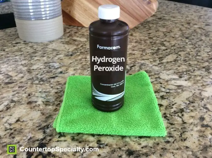 cleaning granite - hydrogen peroxide bottle on gold granite countertops