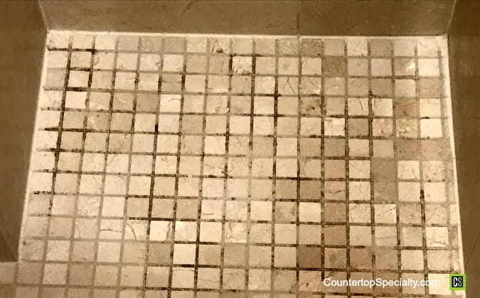 mold & mildew in grout of marble shower floor tile