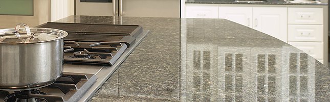 A polished granite countertop is glossy, smooth, and reflective like a mirror