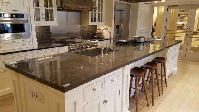 brown porcelain kitchen countertops on a large island with white cabinets