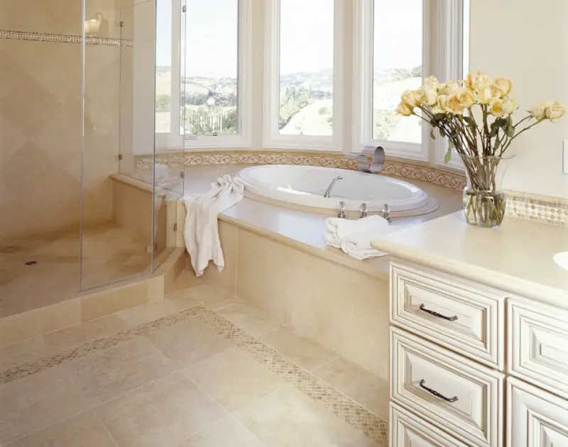 travertine tile shower, floor, tub surround, and countertops in luxury bathroom