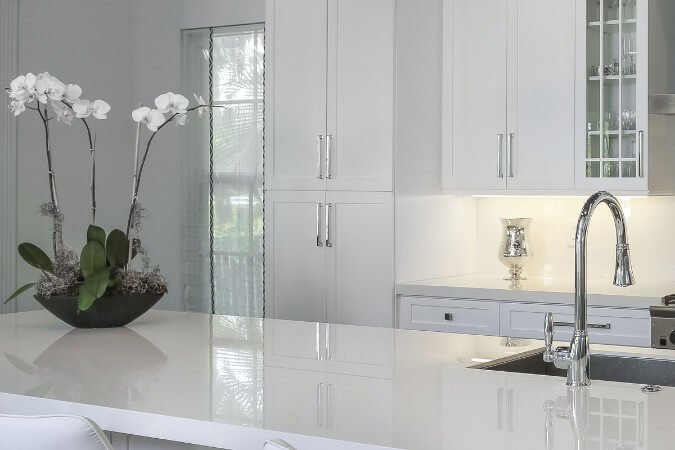 pure white polished neolith countertops in an upscale all white kitchen